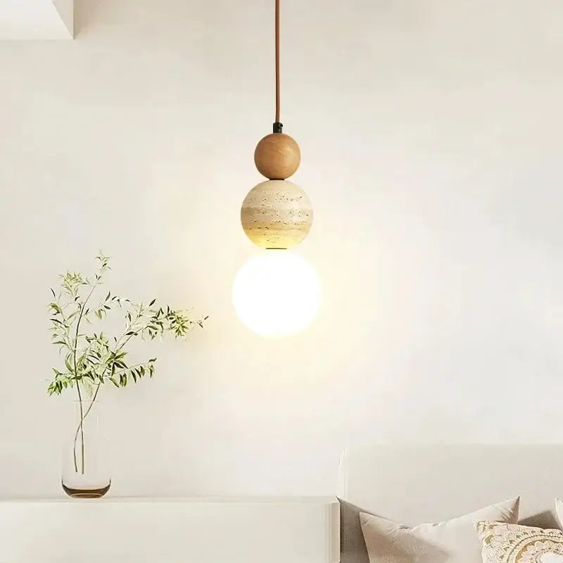 Minimalist bauhaus pendant light with stacked wood and beige stone spheres and a slender brown cord for led bulb use