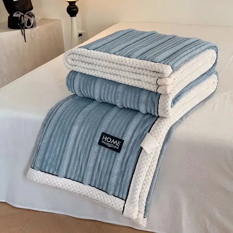 A soft light blue plush blanket with white knitted border and black home label from decorbites cozy faux rabbit collection