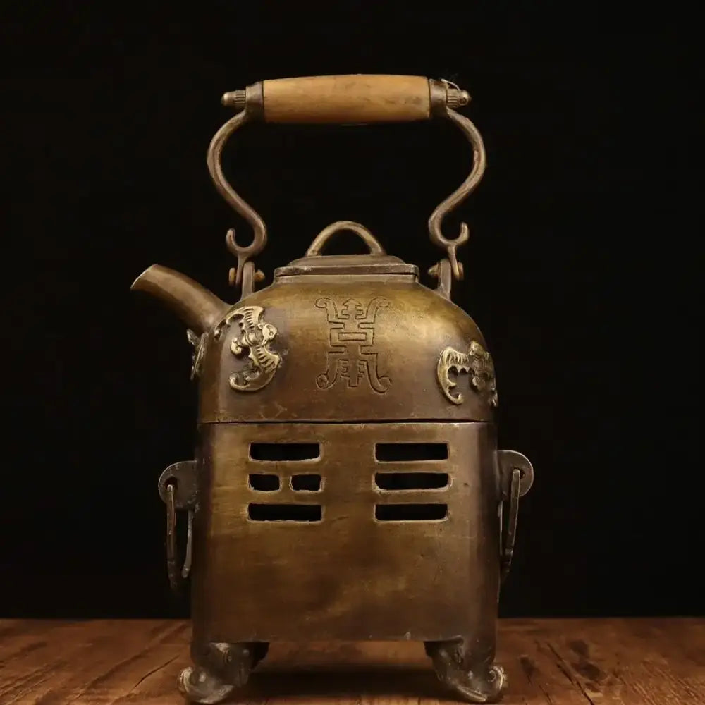 Antique brass warm wine pot with wooden handle, ornate dragon motifs, and Chinese character engravings from DecorBites™