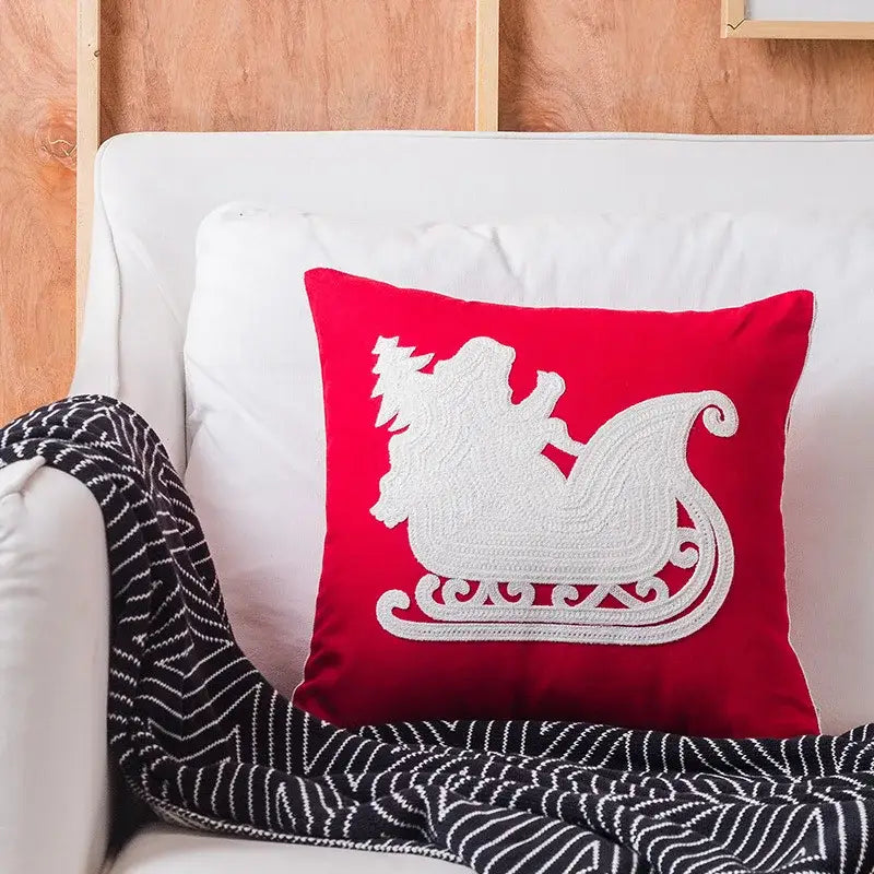 Red square pillow with white embroidered sleigh design from decorbites christmas snowflake elk collection