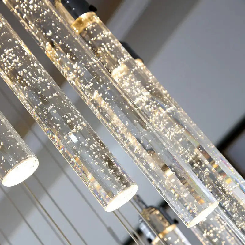 Clear glass cylindrical pendant lights with golden bubbles and warm led illumination in decorbites crystal chandelier