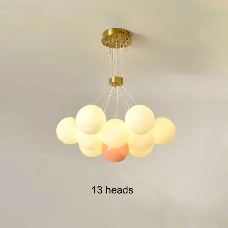A decorbites led lunar ball ceiling chandelier with 13 soft white, cream, and peach glass bulbs for home decor