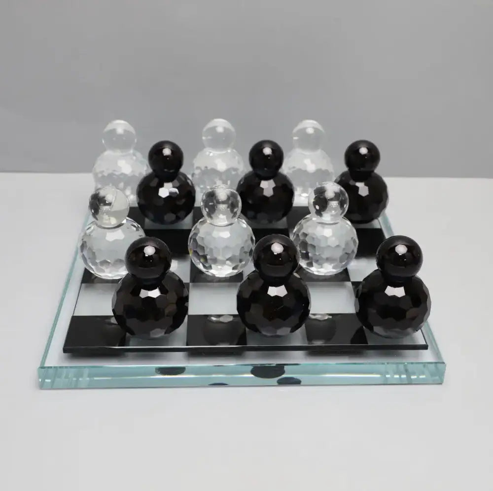 Black and clear faceted glass checkers on transparent glass chess set for geometric blue and clear glass chess living room decor