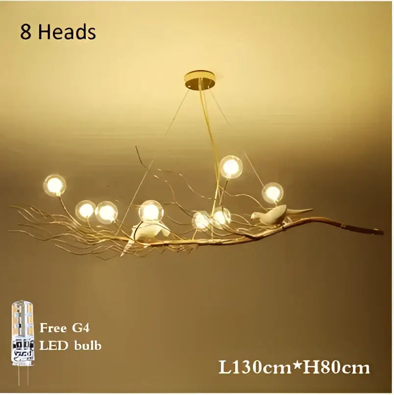 A gold and white iron branch led pendant chandelier with eight glowing bulbs and bird figurines for dining room use