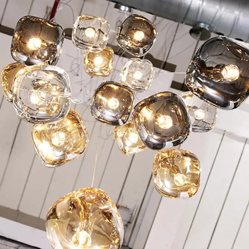A modern amber and smoky grey crystal staircase chandelier with irregular glass orbs for dining room lighting
