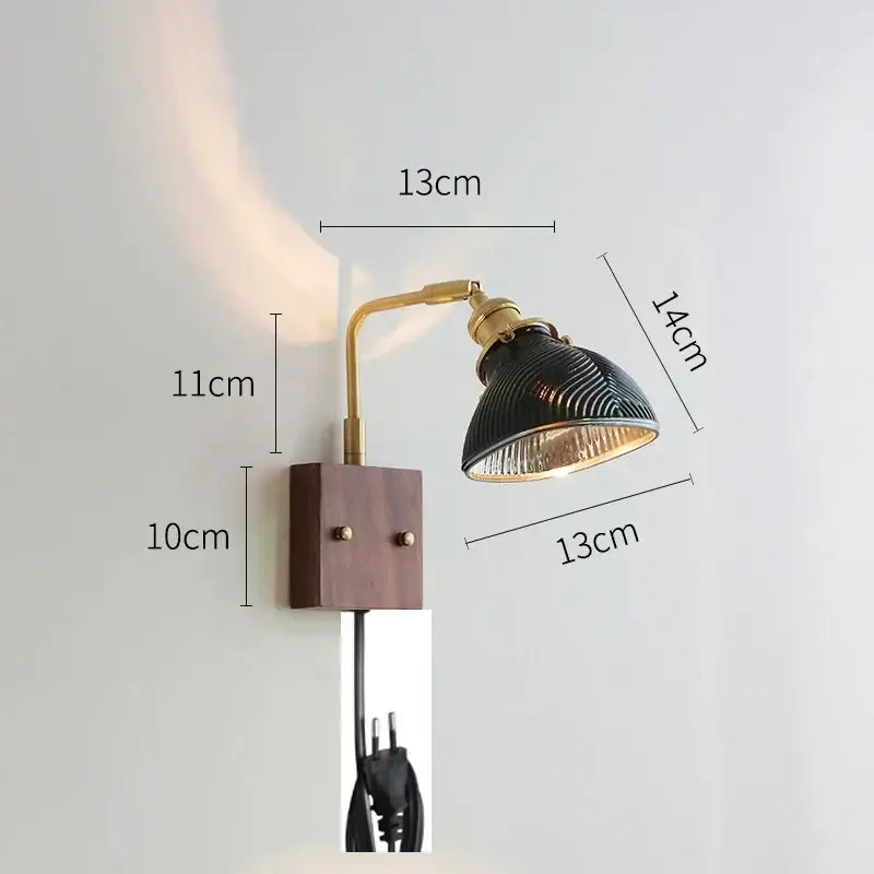 A vintage-style wall light with brass arm and dark green ribbed glass shade on wooden base décorbites clear glass design