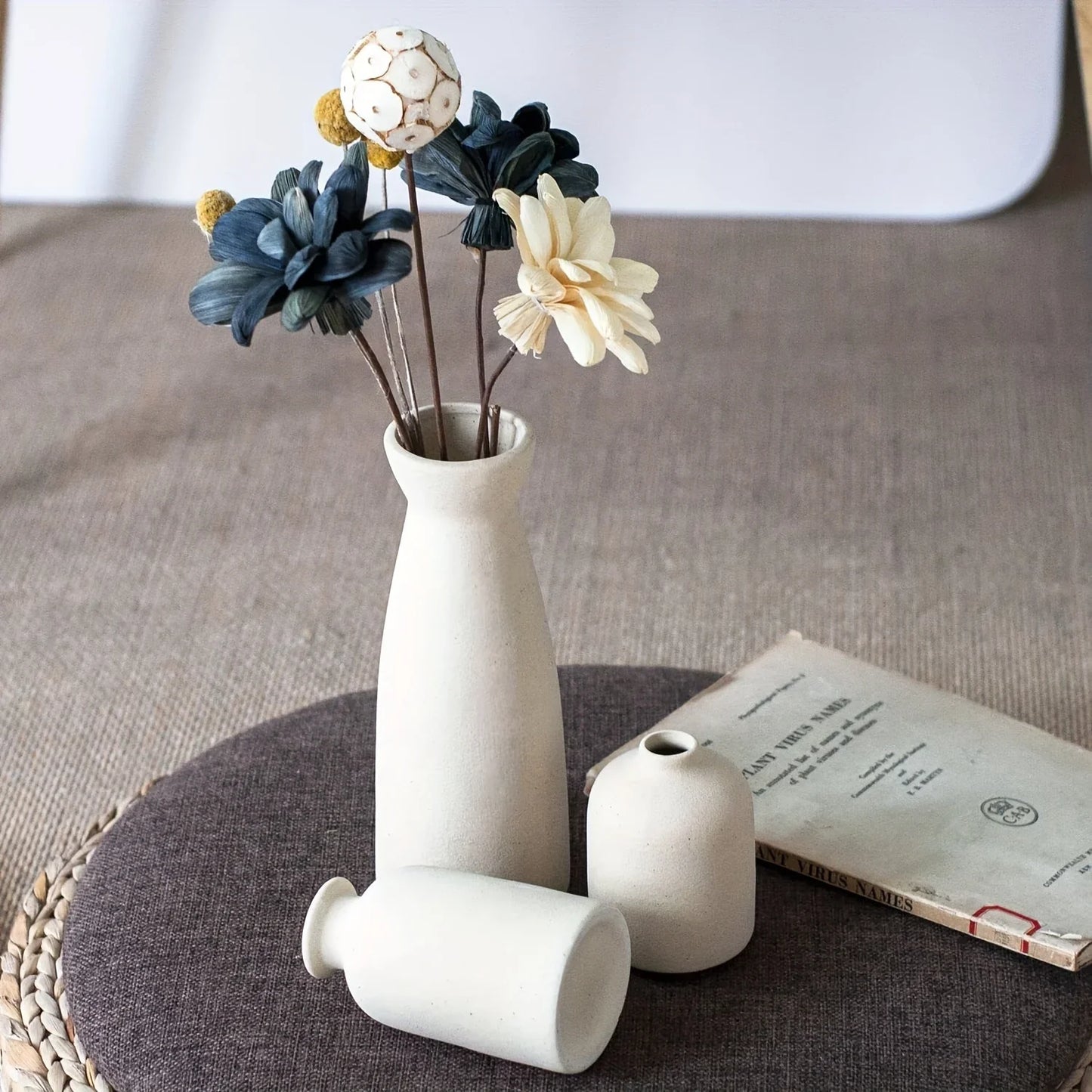 Set of 3 ceramic vases with a minimalist white ceramic vase holding blue cream and yellow dried flowers for rustic decor
