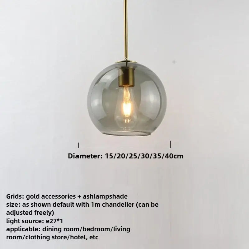 Modern pendant light with smoky gray glass globe, iron finish, gold accents, and exposed edison bulb light source