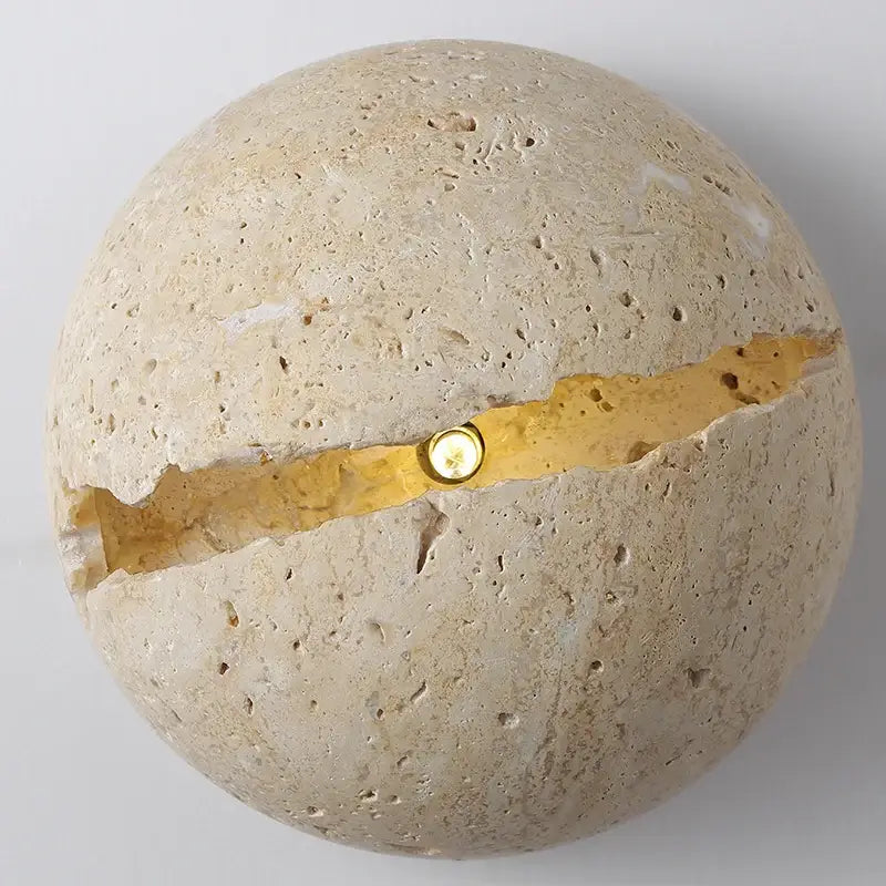 Yellow travertine dino egg stone wall lamp with textured beige surface and gold accent crack by decorbites dino egg wall lamp