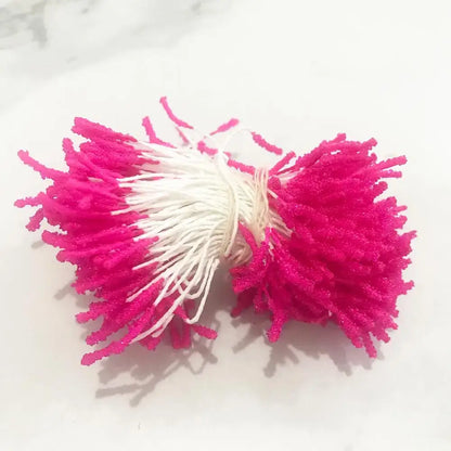 A vibrant pink and white pom-pom hair tie from the 200pcs mixed rose red flower stamen bundle for diy decor