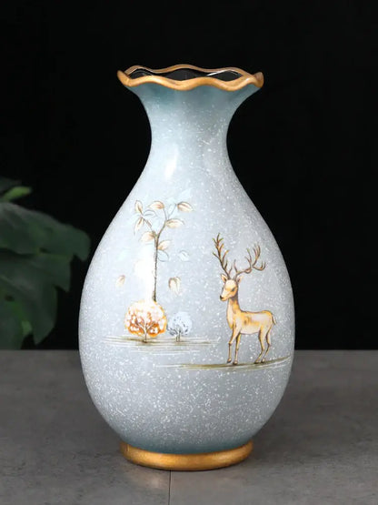 A light blue ceramic vase with gold-rimmed fluted neck and 3D hand-painted deer motifs for dried flowers