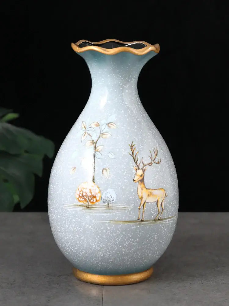 A light blue ceramic vase with gold-rimmed fluted neck and 3D hand-painted deer motifs for dried flowers