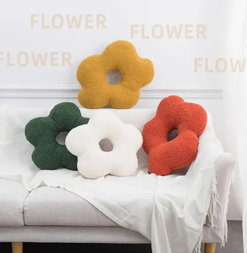 Three plush 3d flower decor nordic cushions in mustard yellow forest green and coral red with central hole for living room use