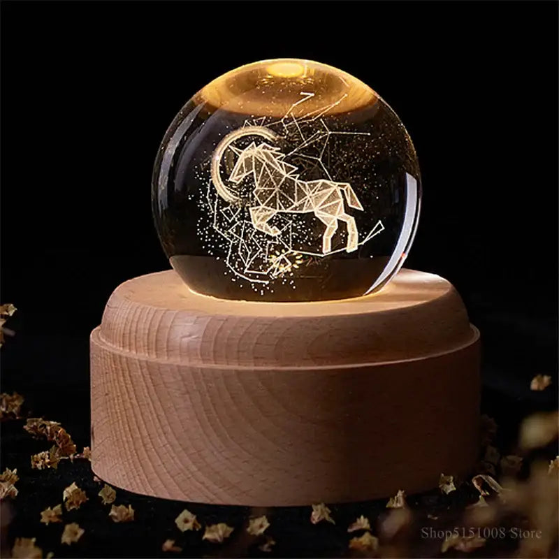 A glowing aries constellation glass sphere night light on a light wooden base decorbites crystal ball night decor
