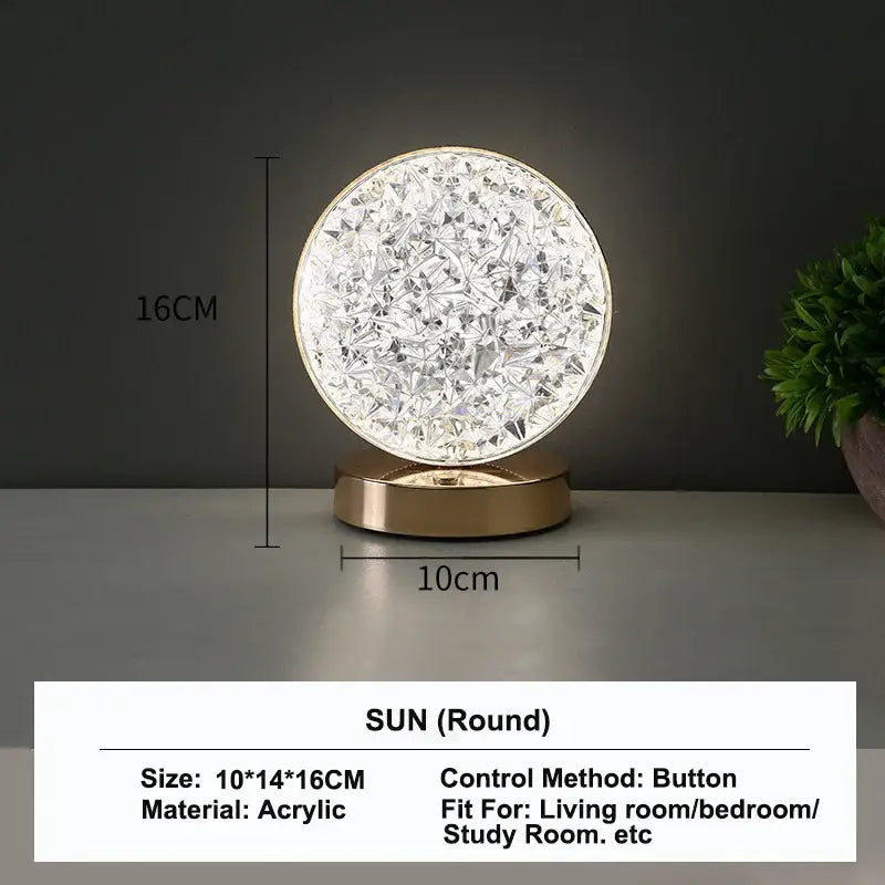 A round 16cm acrylic table lamp with faceted crystal design and gold base featuring touch dimming night light function