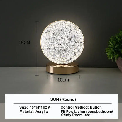 A round 16cm acrylic table lamp with faceted crystal design and gold base featuring touch dimming night light function