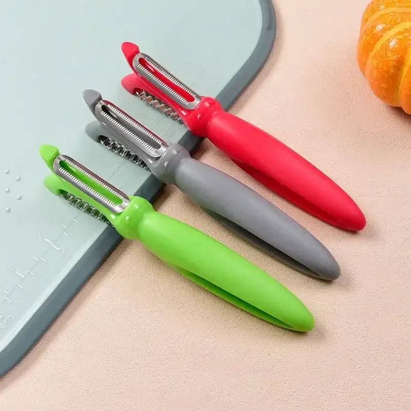 Set of three colorful stainless steel vegetable peelers with ergonomic red gray and green silicone handles