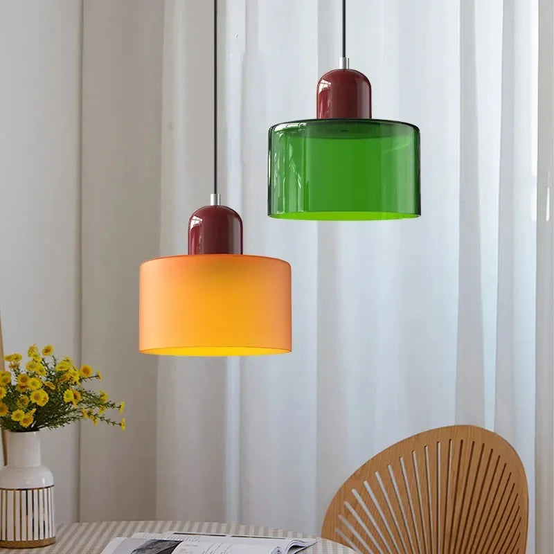 Modern pendant light set with vibrant green and orange glass shades and glossy red metallic tops for kitchen dining room