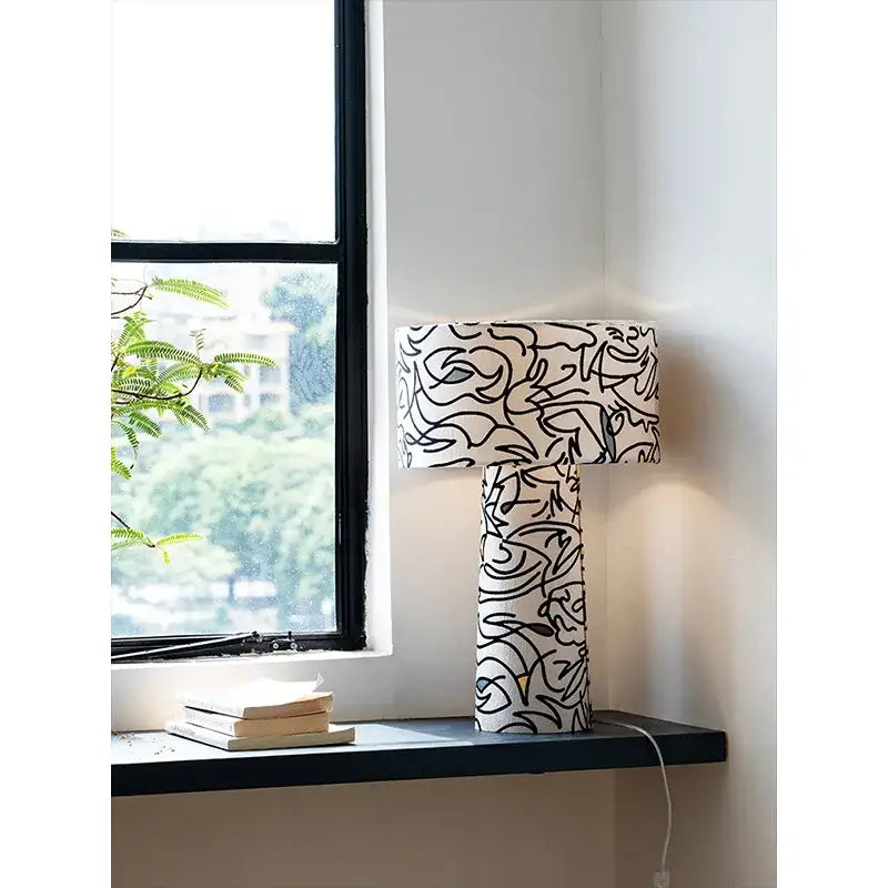 Modern study lamp with black abstract line art on white fabric base and shade from decorbites designer french medieval collection