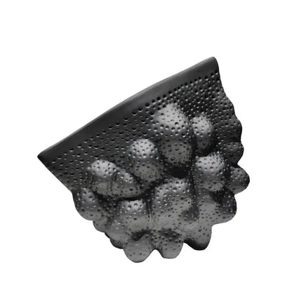 Black ceramic pleated wall-mounted shelf with textured perforated surface and rounded protrusions for modern decorbites decor