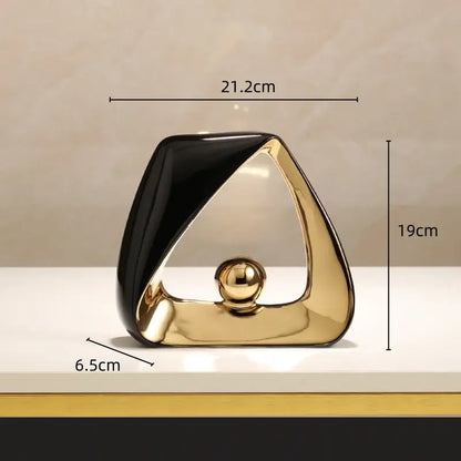 Abstract black and gold ceramic geometric triangles sculpture with a polished golden ball for modern home decor