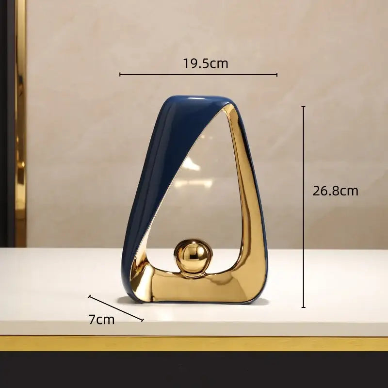 Modern abstract ceramic geometric triangles sculpture with glossy navy blue and gold finish featuring golden ball for home decor