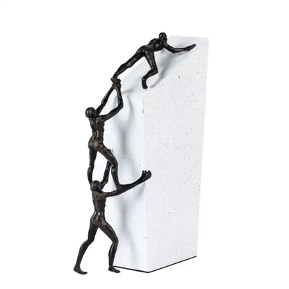 Bronze-colored decorbites gymnast metal handicraft figure showing three stylized figures in chain-link pose on white base