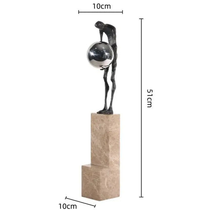 A sleek dark bronze gymnast metal handicraft figure holding a silver sphere on a beige marble pedestal for decorbites gymnast metal decor