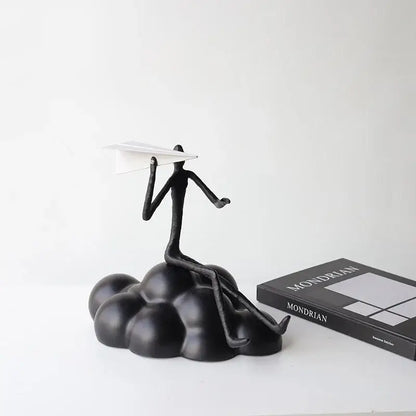 Abstract black resin paper airplane cloud figurine of stick-figure person holding white paper airplane for living room decor