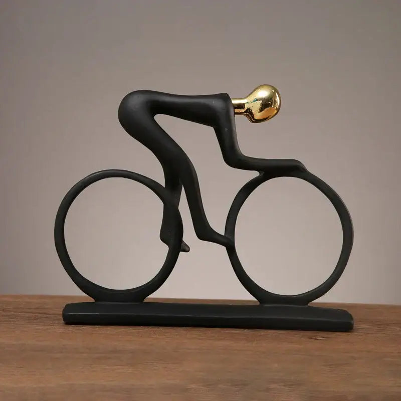 Black sculptural cyclist statue with gold head and glossy finish made of decorbites abstract resin for living room decor