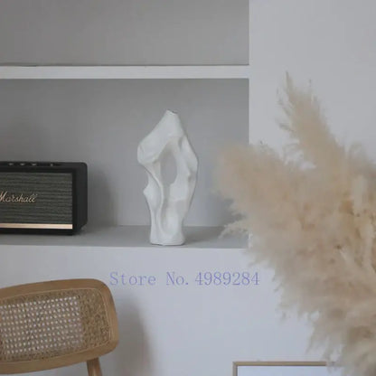 A sleek white abstract ceramic vase with organic form by decorbites black sits elegantly on a shelf for living room decor