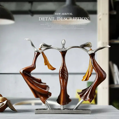 Abstract bronze dancing couple sculpture featuring polished bronze bodies silver limbs and flowing orange gold fabric drapes