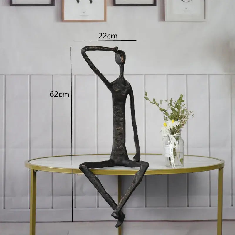 Abstract bronze metal human sculpture with elongated limbs in contemplative pose for living room decorbites abstract metal decor