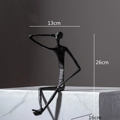 Black textured abstract metal human sculpture of slender seated figure with raised arm for living room decorbites decor