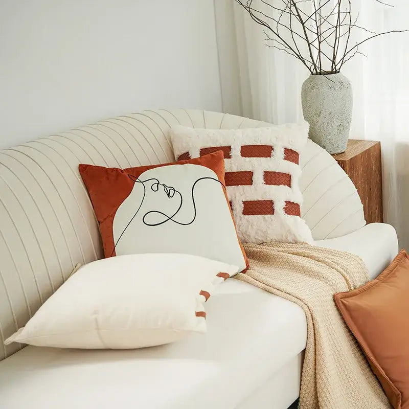 Cream-colored pillow cover with minimalist black abstract face line art for burnt orange decorbites abstract plush decor