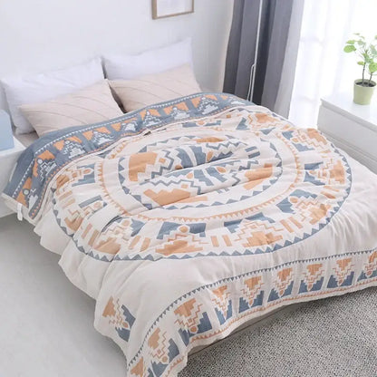 A cozy cream-colored cotton nordic throw blanket with bold blue and orange geometric concentric circles by decorbites