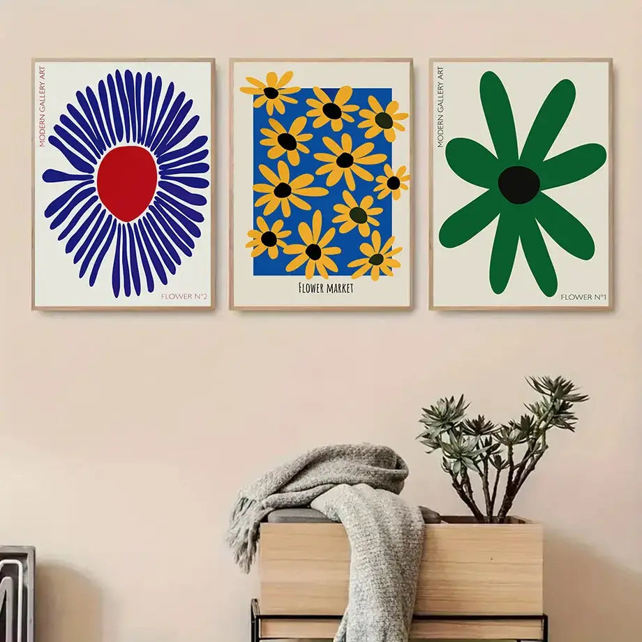 Three framed modern floral flowers wall art prints with bold blue, red, yellow, and green stylized designs on canvas