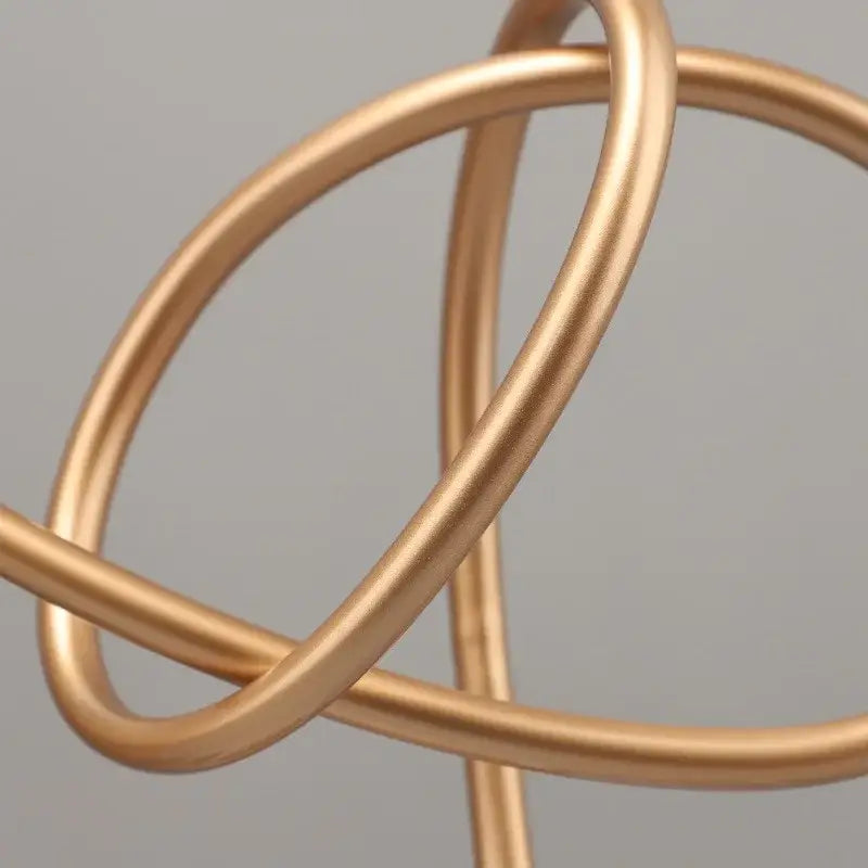 Abstract gold line geometric metal sculpture featuring gold-toned metal wire with interlocking circular loops for decorbites gold line living room decor