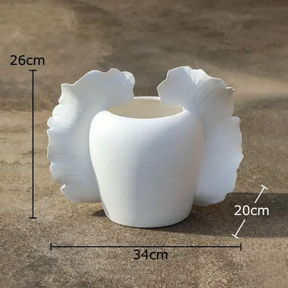 White ceramic butterfly wings vase with sculpted leaf-like flares for abstract gray and orange bedroom decor