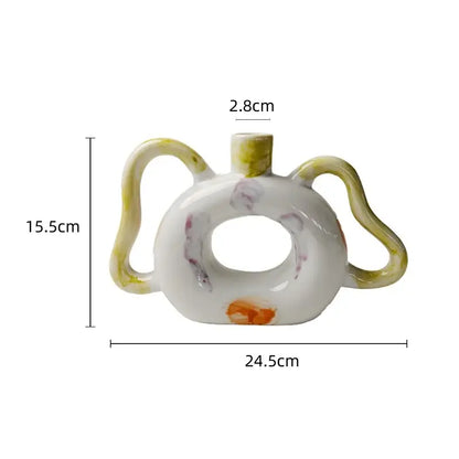 A white ceramic miniature teapot with donut-shaped body and yellow abstract handle decorbites abstract handle ceramic vase set