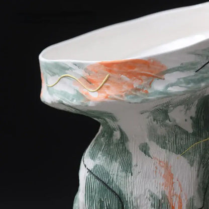 A ceramic vase with an abstract irregular pattern in green and orange featuring gold wire accents for living room decor