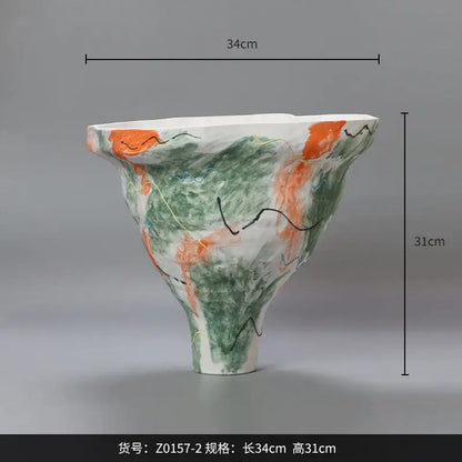 A handcrafted ceramic vase with an abstract irregular pattern of green orange and black for living room decor