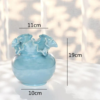 A light blue decorbites ceramic shell vase with a rounded body and ruffled rim for living room decor