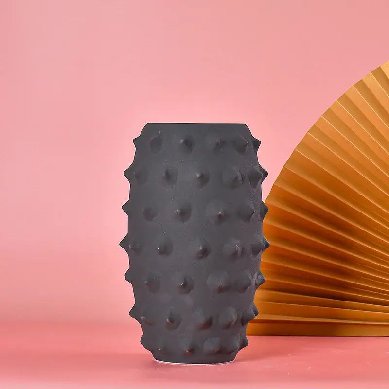 Black ceramic sea urchin vase with textured spiky surface by decorbites for living room decor