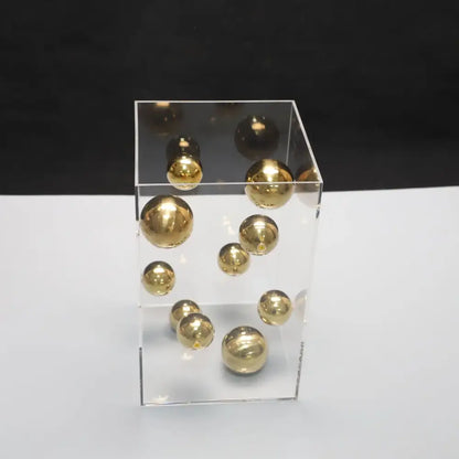 Transparent acrylic cube container holding polished golden metal balls for decorbites abstract metal ball artworks