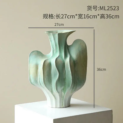 Abstract mint and olive ceramic vase with irregular folds in flowing organic curves for living room decor