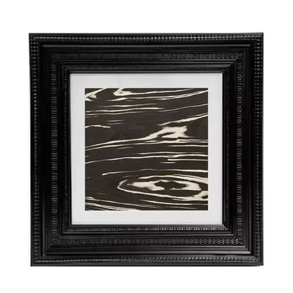 Black ornate picture frame holding decorbites abstract modern wall art with swirling white lines on dark brown background