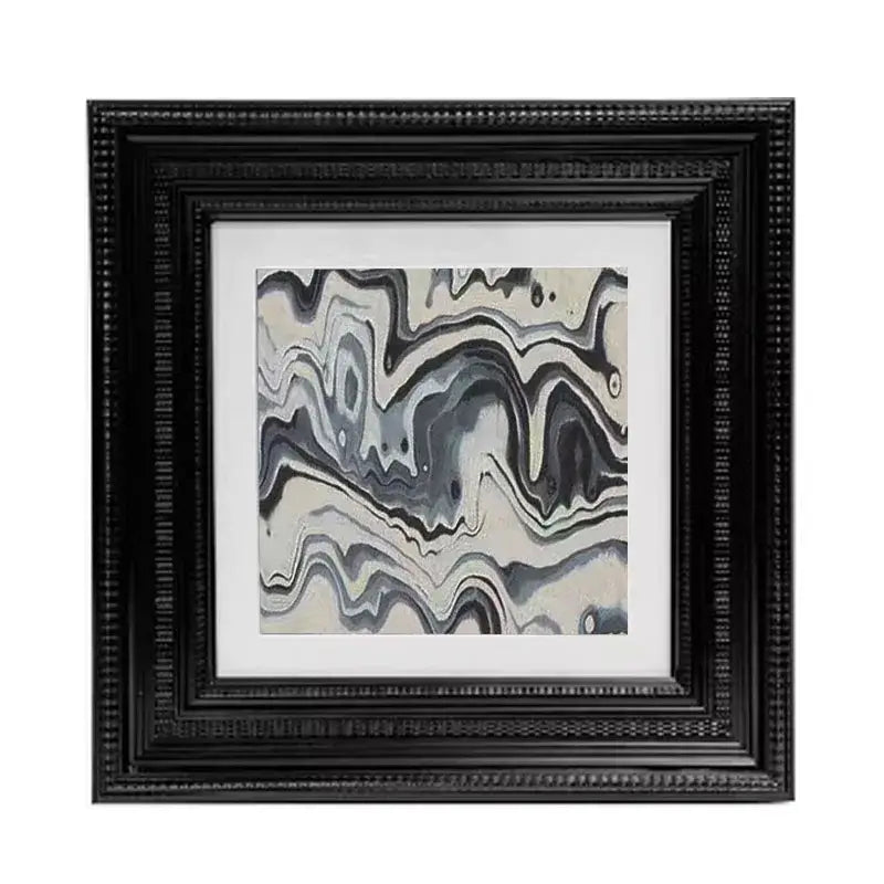 Black beaded picture frame holding abstract modern wall art with flowing gray white and black swirls for decorbites decor