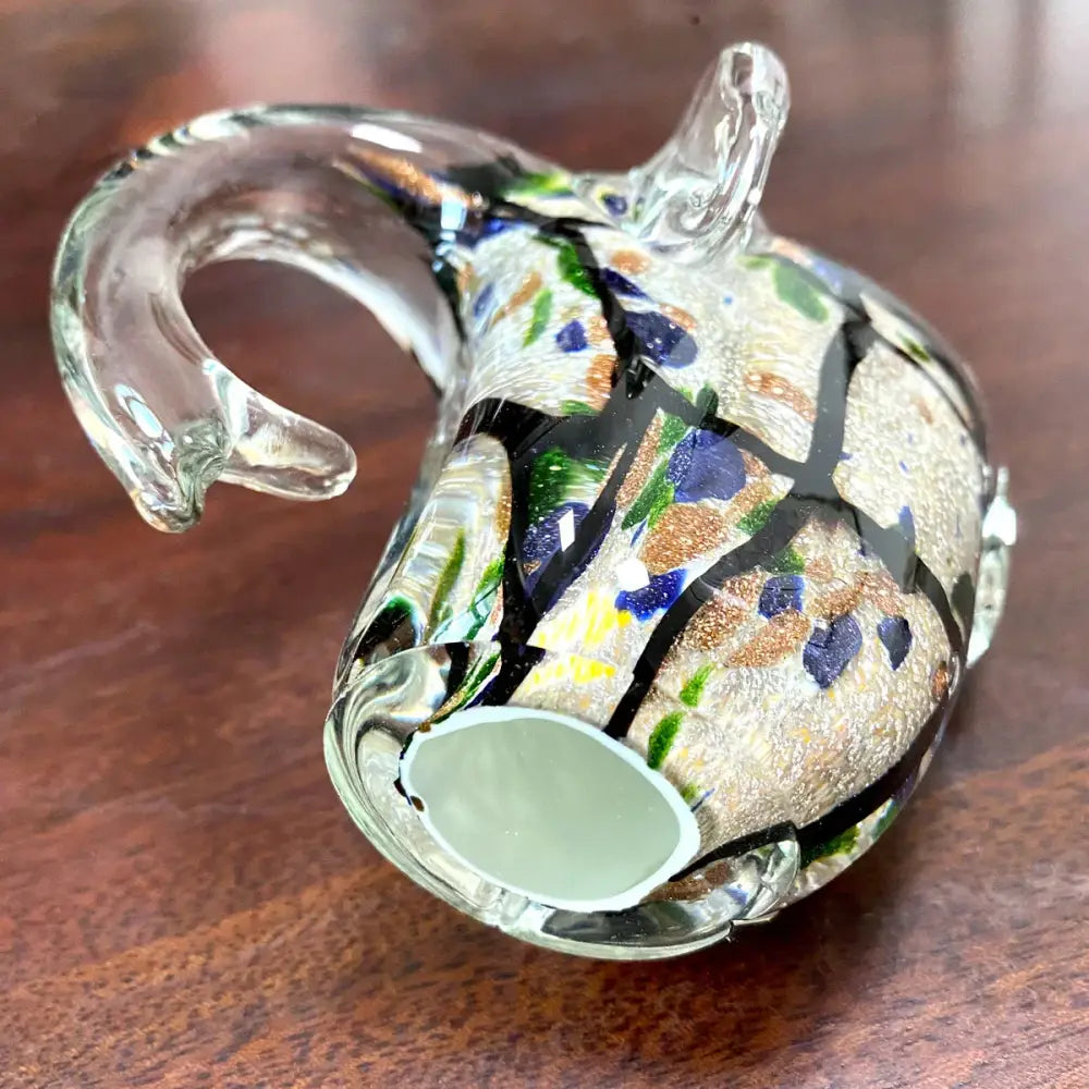 A decorbites elephant crystal glass sculpture with a mosaic pattern of black blue green and gold flecks for living room decor
