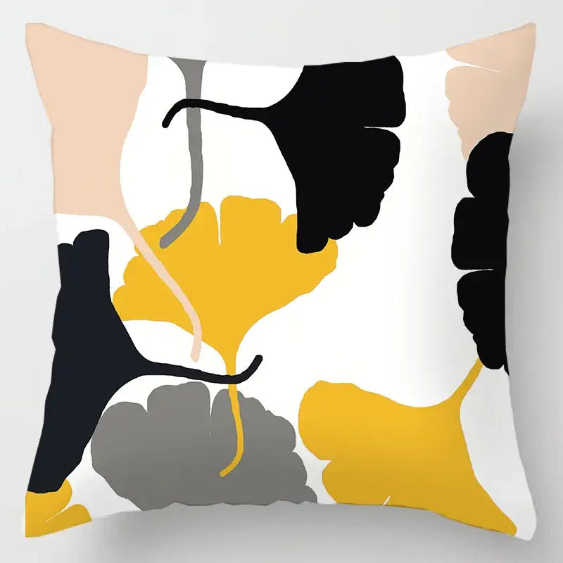 A square cushion cover with a geometric leaves print of black yellow and gray ginkgo leaves on white background